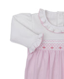 White and pink sleepsuit with ruffled collar and cuffs, smocked bodice with pink embroidery and roses.