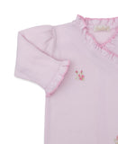 Pink knit sleepsuit with ruffled V-neckline and cuffs, puffed sleeves, and small embroidered pink rosebuds on the chest.