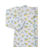 White sleepsuit with yellow lemon and blue floral print, long sleeves, and a snap-button placket with blue ruffled trim.