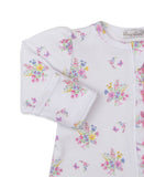 White sleepsuit with long sleeves, multicolor floral and butterfly print, and pink ruffled trim down the front.