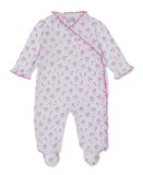 White long-sleeved, footed sleepsuit with pink tulip print. Features a wrap-style front with pink ruffled trim and snap closu