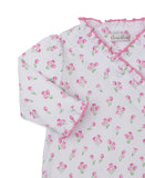 White sleepsuit with pink tulip print, wrap front, snap closure, and pink ruffled trim on neckline and cuffs.