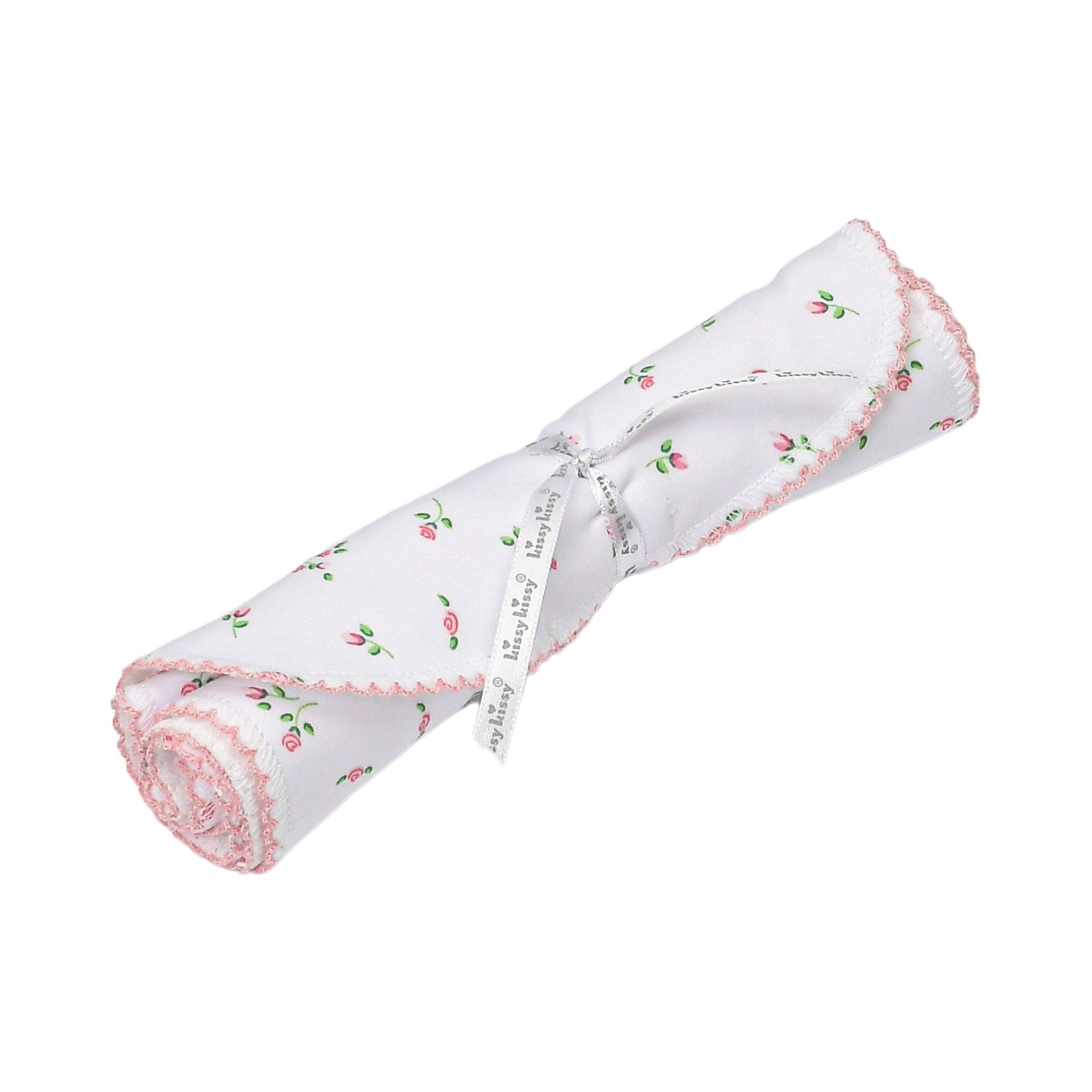 White fabric item rolled up, featuring a pink rosebud print, pink scalloped trim, and tied with a "kissy kissy" ribbon.