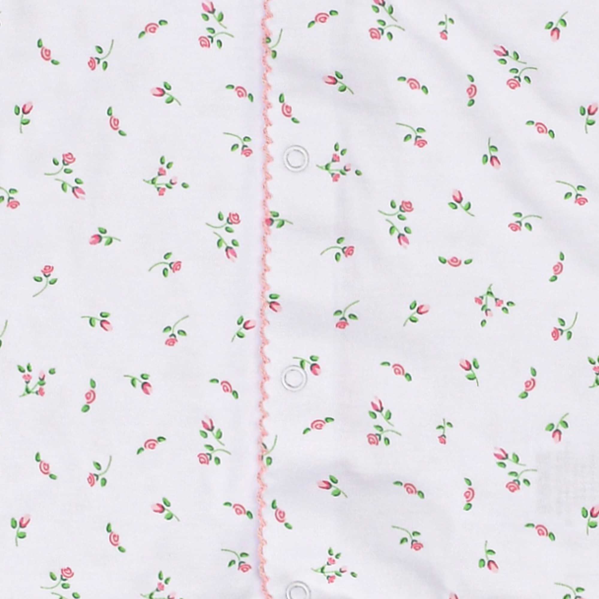 White fabric garment with a small pink rose and green leaf pattern, featuring a vertical placket with pink scalloped trim and