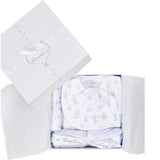 White gift box with light blue ribbon, containing white baby clothes and blanket with light blue teddy bear print and scallop