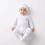 White sleepsuit with front snaps, blue teddy bear embroideries, and blue scalloped trim. Matching white beanie with blue tedd