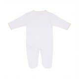 White long-sleeved sleepsuit with enclosed feet, featuring gold-toned ruffled trim on the round neckline and sleeve cuffs.
