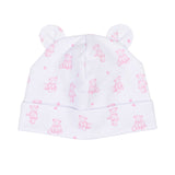 White baby hat with a folded brim and two small ears on top, featuring an all-over print of pink teddy bears and paw prints.