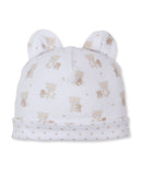 White baby beanie with two rounded ears, featuring an all-over tan teddy bear and star print, with a folded brim.