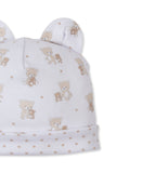 White baby hat with bear ears, featuring an all-over tan teddy bear and star print, and a star-patterned cuff.