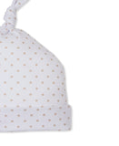 White baby hat with a knotted top and folded brim, covered in small tan star print.