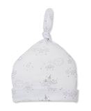 White baby beanie hat with a knotted top, featuring a grey pattern of sleeping suns, clouds, stars, and moons.