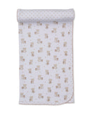 Tan and white knit baby blanket with an all-over pattern of light brown teddy bears and small stars, rolled up.