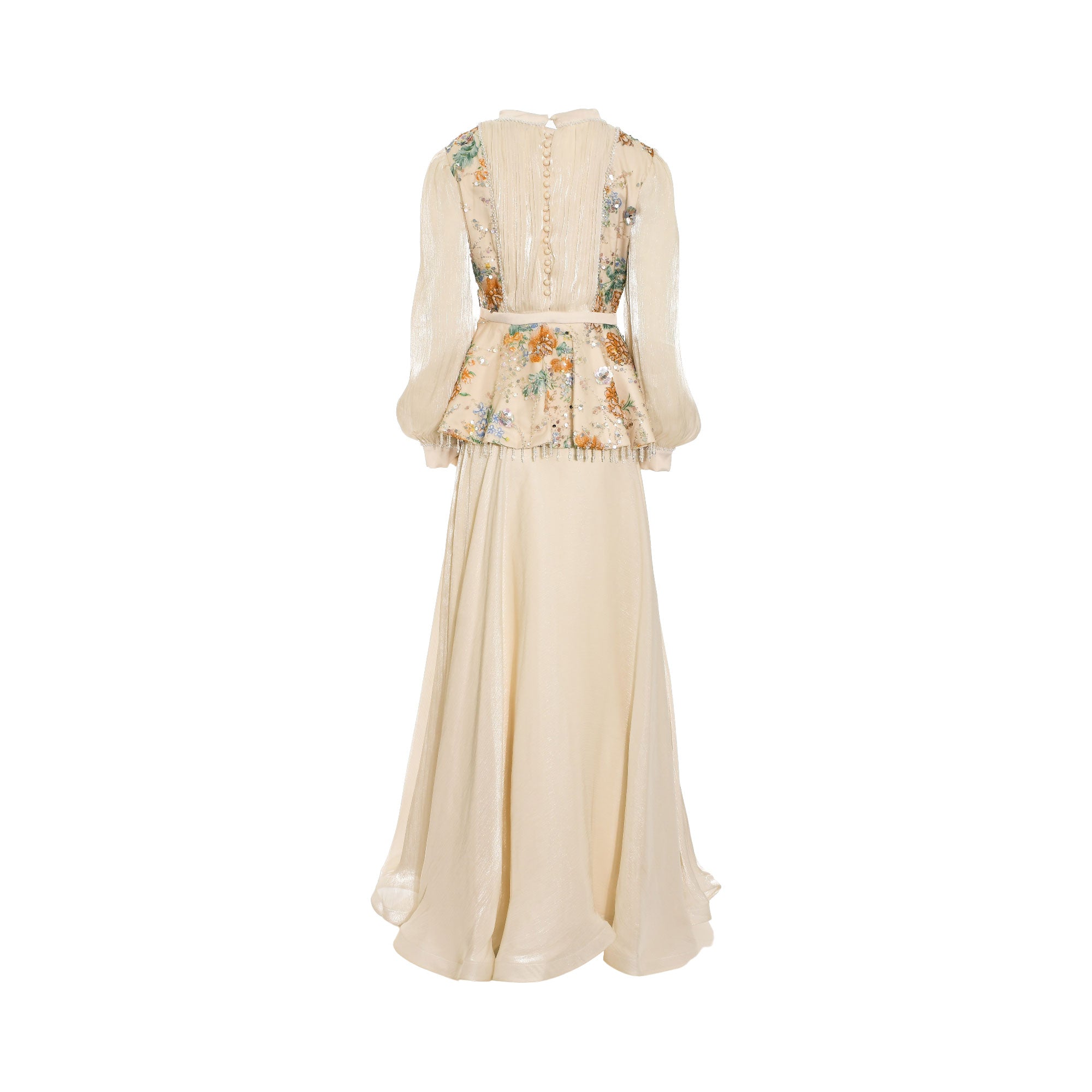 Beige long-sleeve top and maxi skirt set. Top features a high neck, sheer sleeves, buttoned back, and a floral sequined peplu