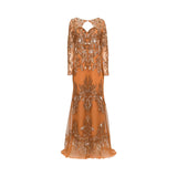 A floor-length orange gown with long sleeves, a V-neckline with a keyhole cutout at the back, and extensive gold sequin embroidery, shown against a plain white background.
