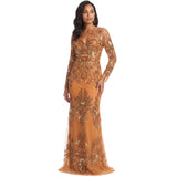 A woman modeling a floor-length, long-sleeve gown in warm camel tan with extensive metallic gold sequin and bead embroidery, set against a plain white background.