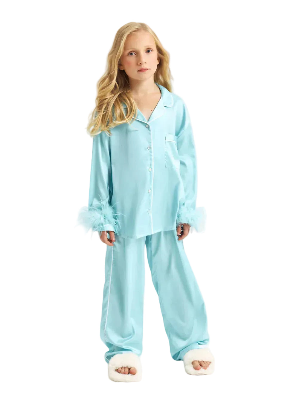 Full-length front studio shot of a young girl modeling the Katee's Kids turquoise silk pajama shirt and trousers, detailed with white contrast piping, front buttons, a chest pocket, and matching feather cuffs.