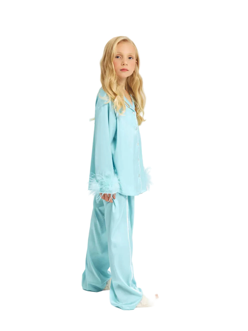 Side view of a young blonde girl wearing the Katee's Kids turquoise silk pajama set, highlighting the fluid, wide-leg cut of the trousers and the fluffy feather wrist cuffs.