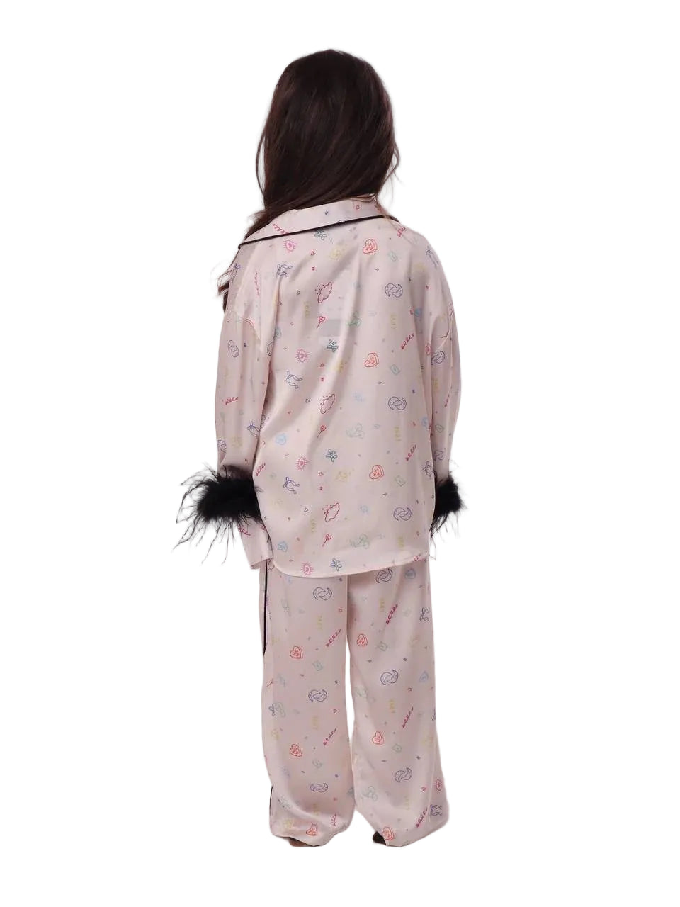 Back view of a young girl wearing the Katee's Kids pink doodle-print silk pajama trousers and matching long-sleeve shirt, highlighting the relaxed fit and black cuffs.