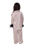 Back view of a young girl wearing the Katee's Kids pink doodle-print silk pajama trousers and matching long-sleeve shirt, highlighting the relaxed fit and black cuffs.