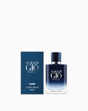 Dark blue to clear gradient glass perfume bottle with a dark blue cap and silver-toned neck, next to its matching dark blue b
