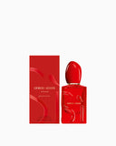 Red perfume bottle with gold-toned neck, glossy red egg-shaped cap, and raised 'Si' lettering. Matching red box with wavy des