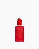 Red rectangular perfume bottle with a matte finish, embossed 'SI' lettering, a glossy red rounded cap, and a gold-toned neck