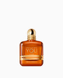Amber-coloured rectangular glass perfume bottle with a gold-toned spherical cap and horizontal gold bands.