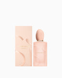 Light peach perfume bottle with a gold-toned neck and oval cap, featuring raised abstract shapes. Matching rectangular box wi