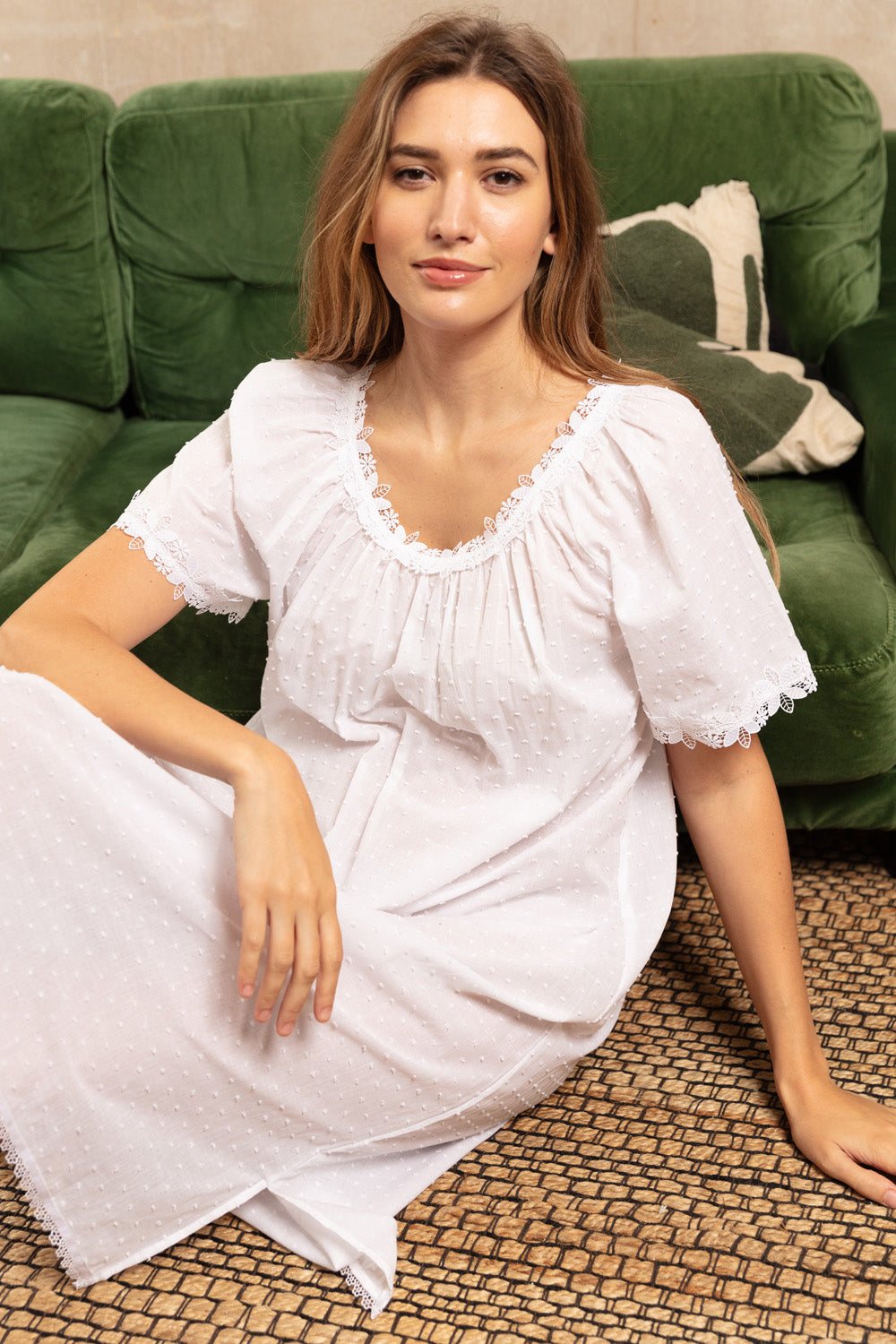 White swissdot midi dress with short puffed sleeves and a gathered square neckline, both trimmed with white lace.