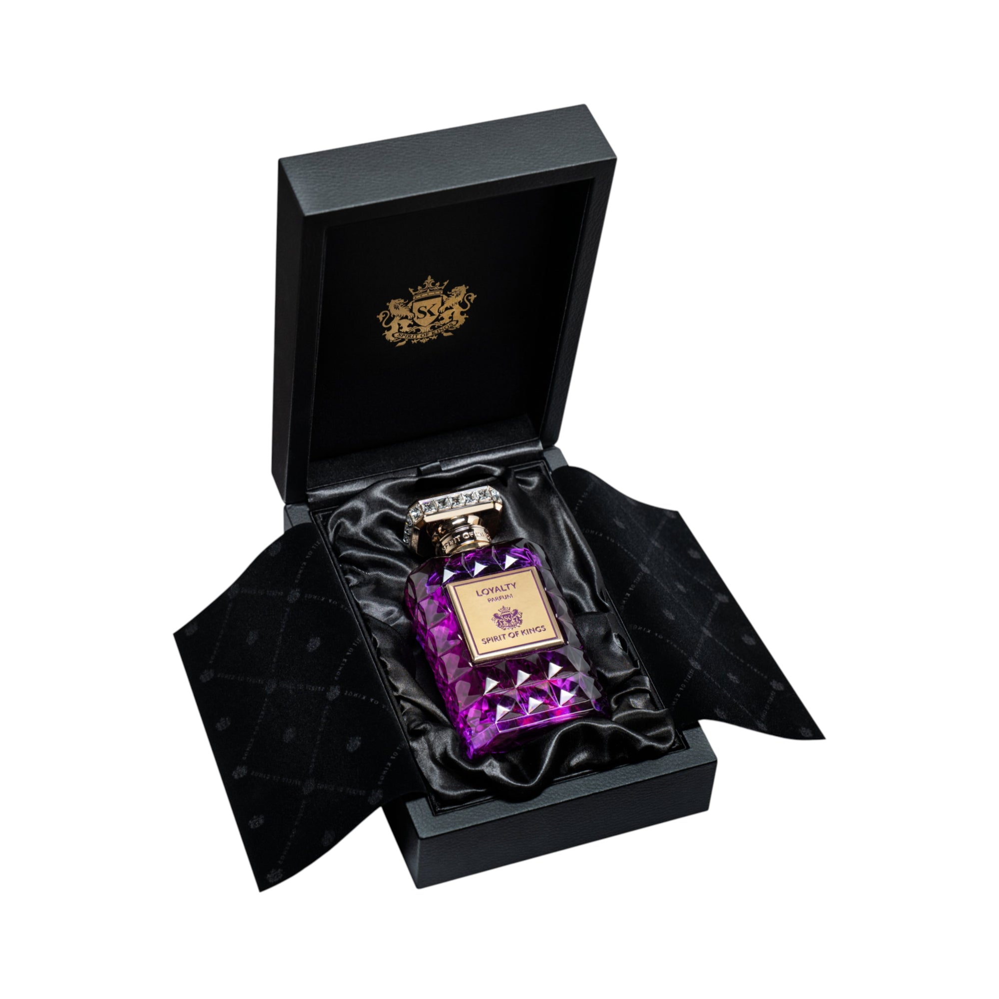 Purple faceted glass perfume bottle with a gold-toned label and crystal-studded cap, presented in an open black satin-lined b