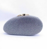 Black oval evening clutch, fully embellished with silver-toned rhinestones, with a gold-toned clasp.