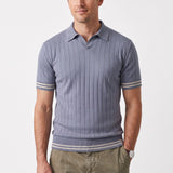Light blue men's short-sleeved knit polo shirt with vertical ribs, flat collar, V-neck, and beige striped cuffs and hem.