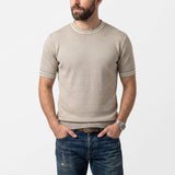 Beige knit short-sleeved top with a ribbed crew neck and cuffs, both featuring white and dark grey stripes.