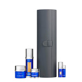 A premium La Prairie Switzerland skincare gift set featuring a tall, charcoal grey cylindrical leather-style vanity case with a strap closure. Arranged in front are five Skin Caviar products in signature cobalt blue and silver packaging: Luxe Cream, Liquid Lift (showing visible caviar beads), Luxe Eye Cream, Eye Lift (travel size), and a miniature Essence-in-Lotion.