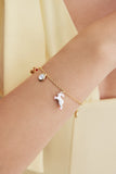 Les Néréides MULTIVERS Women's Delicate Bracelet Bracelet with a unicorn charm on a wrist against a light yellow background