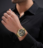 Lifestyle shot of the Police watch PEWGK0039208 worn on a man's wrist, paired cleanly with a tailored black button-up shirt to showcase how the gold styling contrasts against dark menswear.