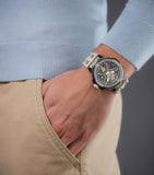 Lifestyle shot of the Police watch PEWGR0082201 on a model's wrist, styled with a light blue pullover sweater and beige chinos to accentuate the subtle neutral colorway of the timepiece.