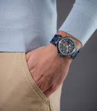 Lifestyle shot of the Police watch PEWGR0082204 on a model's wrist, styled with a casual blue knit sweater and beige khakis to emphasize the athletic, transparent design.
