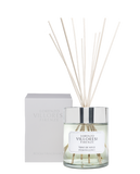 A luxury room fragrance set by Lorenzo Villoresi Firenze. The image features a clear glass diffuser jar filled with pale liquid and several natural wood reeds fanning out from a polished silver collar. The jar label and the accompanying minimalist white presentation box both feature the brand name and "TEINT DE NEIGE ROOM FRAGRANCE" in elegant black typography.