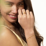Delicate gold-toned chain bracelet with multiple small, teardrop-shaped charms, some featuring tiny clear stones.
