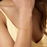 Gold-toned chain bracelet with five small, alternating gold-toned and clear stone-set leaf-shaped charms.
