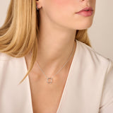 Silver-toned necklace with a delicate chain and an open circle pendant. One half of the circle is smooth, the other half is s
