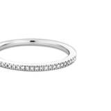 Silver-toned ring with a thin band, half-eternity style, featuring a row of small, clear, sparkling stones.