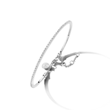 Thin silver-toned bangle, half encrusted with clear stones, half plain. Features a clasp, a small round charm, and an extende