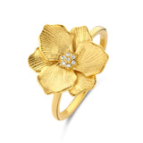 Yellow gold-plated ring with a large, textured floral design and a cluster of clear stones in the centre.