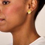 A yellow gold-toned flower stud earring with textured petals and a small clear stone in the center.