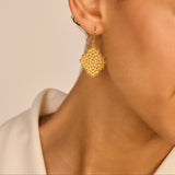Single gold-toned filigree dangle earring with an intricate diamond-shaped design made of small concentric circles.