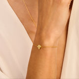 Gold-toned chain bracelet featuring a textured poppy flower charm with four petals.