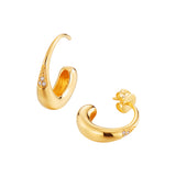 Pair of gold-toned, curved earrings. One is an open hoop, the other a stud. Both feature a textured section with three clear